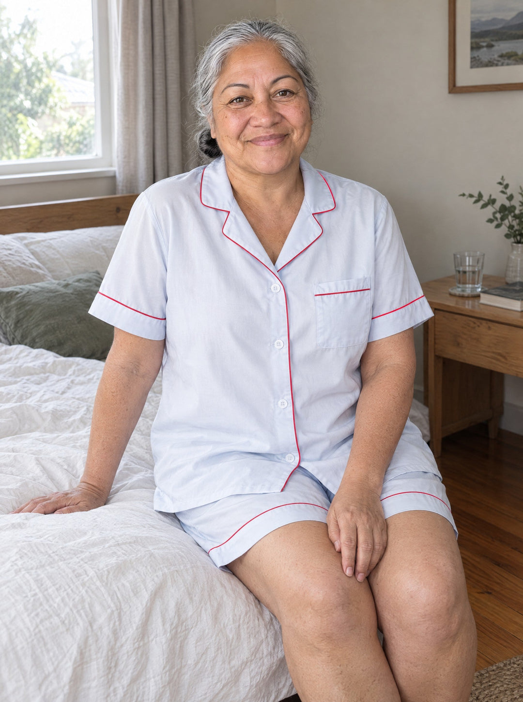Woman wearing the lyocell short pyjama set in light blue with red piping